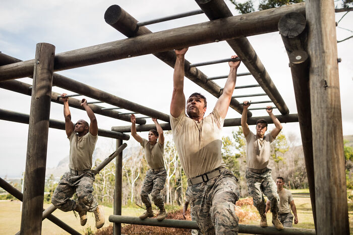 A group of men in military uniforms navigating an obstacle course, illustrating professions attracting the most awful people. - 7