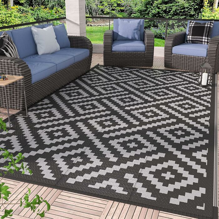 Outdoor patio furniture set with blue cushions on a patterned rug, showcasing Prime Day home deals for stylish outdoor living.