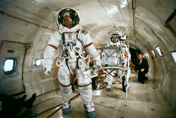 Astronauts in full space suits inside a zero-gravity training aircraft preparing for astronaut facts and space missions.