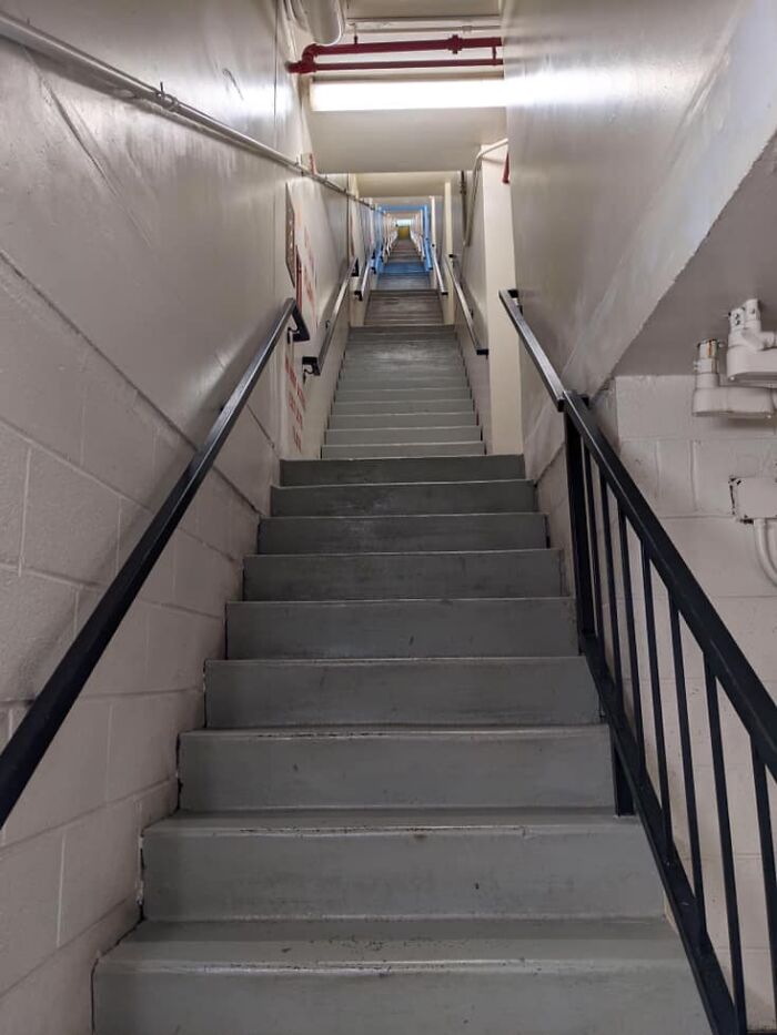 Long flight of death stairs in a narrow stairwell extending straight upward for 13 stories without turning.