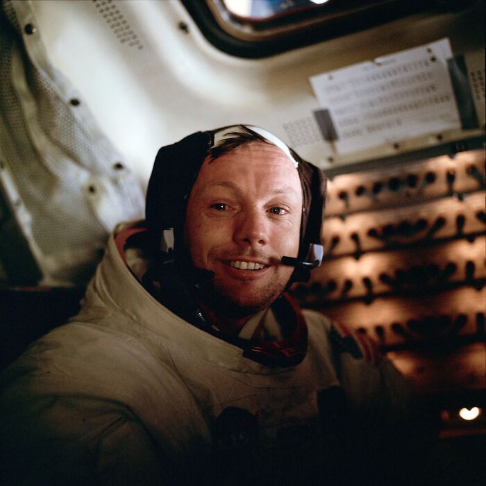 Apollo mission photo of an astronaut smiling inside the spacecraft, showcasing historic space exploration moments.