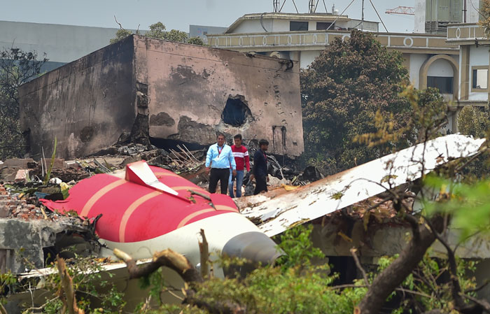 Crash site of doomed Air India plane with investigators examining wreckage amid mysterious object theories after takeoff.
