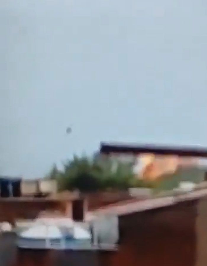 Blurred image showing a mysterious object flying off a doomed Air India plane seconds after takeoff over rooftops.