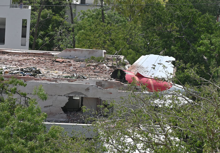 Wreckage of Air India plane showing damaged wing and building after mysterious object flew off seconds after takeoff.