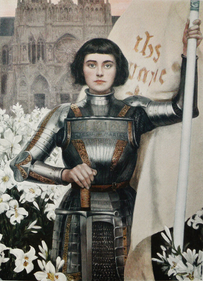 Portrait of a medieval female warrior in armor holding a flag, surrounded by white flowers and gothic architecture behind.