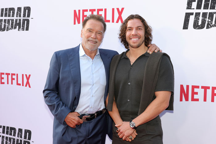 Arnold Schwarzenegger with his look-alike love child posing together at a Netflix movie premiere event. Arnold Schwarzenegger with his look-alike love child posing together at a Netflix movie premiere event.