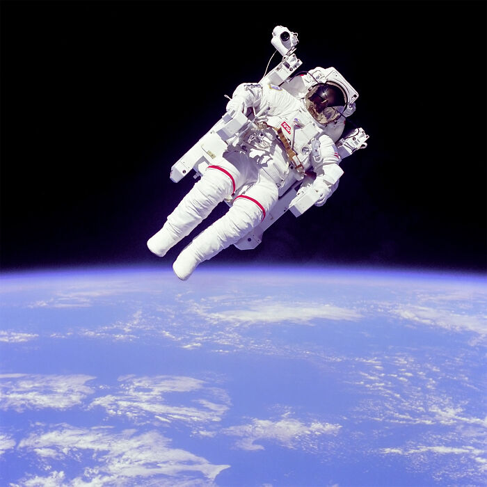 Astronaut floating in space above Earth, showcasing intriguing and bizarre astronaut facts in a spacesuit with equipment.
