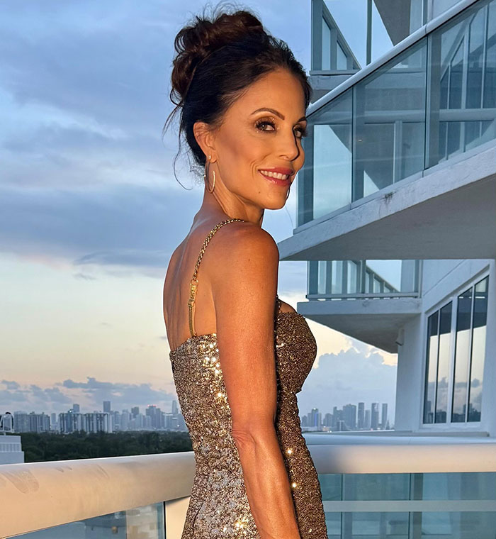 Bethenny Frankel modeling a shimmering dress on a balcony with city skyline, showcasing supermodel diet results.