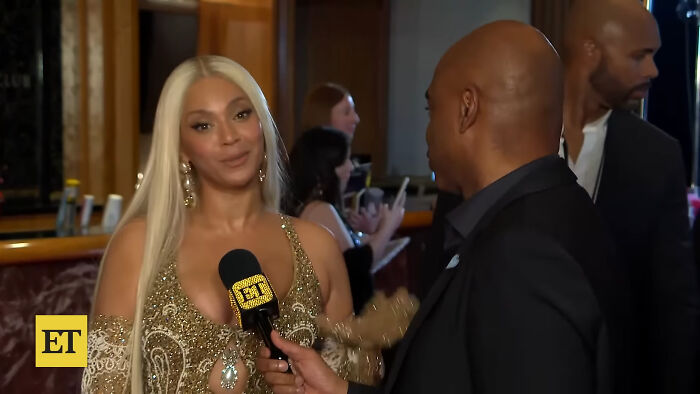 Celebrity woman in gold dress interviewed at event highlighting Hollywood hypocrisy on aging and gender perceptions.