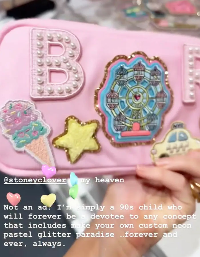 Pink bag with colorful patches including an ice cream cone, star, Ferris wheel, and taxi, related to Blake Lively shopping trip backlash.