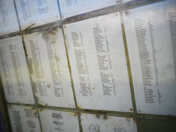 List of names and details displayed on worn, stained papers behind glass at a Catholic home for unwed mothers site. List of names and details displayed on worn, stained papers behind glass at a Catholic home for unwed mothers site.