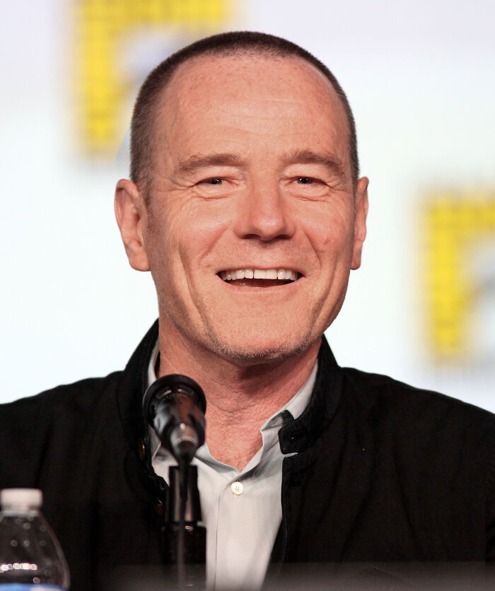 Smiling man speaking into a microphone during a panel, representing late bloomers who became millionaires after being counted out.