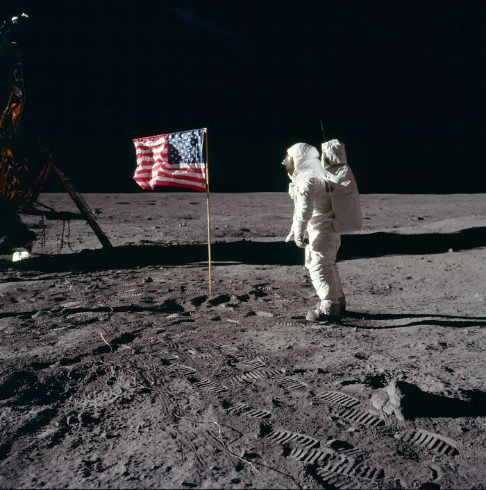 Astronaut on the moon beside the American flag, representing historical facts that amaze and inspire curiosity.