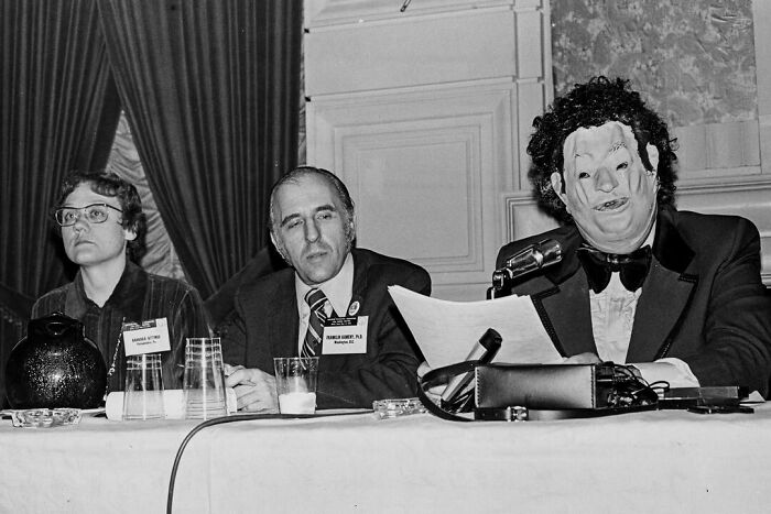 Three people at a panel table, one wearing a vintage mask, illustrating history that looks confusing now.