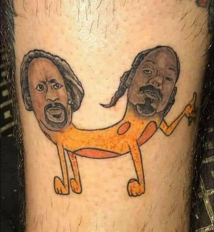 Bizarre tattoo of a two-headed orange dog with faces of two men on human skin showing unusual tattoo choices.
