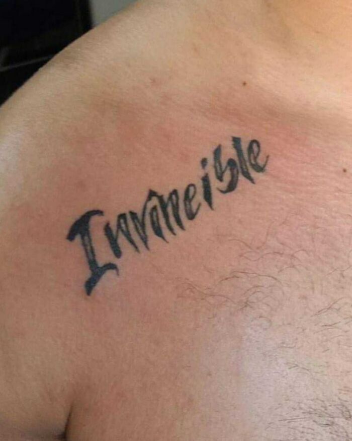 Tattoo with the misspelled word invincible inked on a person's upper chest as a bizarre tattoo choice.