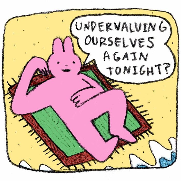 Pink strange little creature lying on a rug by the water, speaking about undervaluing themselves in a comic style.