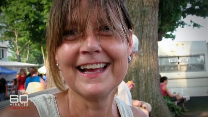 Close-up of woman smiling outdoors, showing her face 16 years after a chimpanzee attack and subsequent face transplant.
