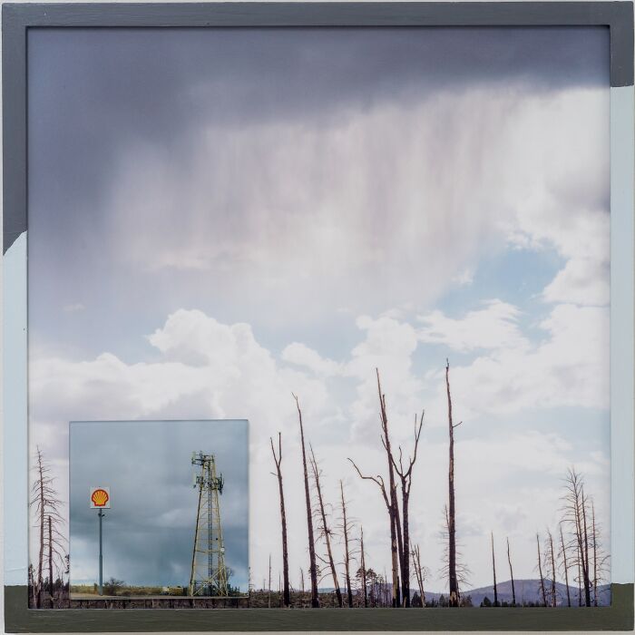Color photography of a cloudy sky over a landscape with bare trees and a Shell gas station sign.