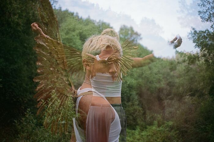Double exposure color photography of a person with wings in a lush green natural setting, artistic photo winner.