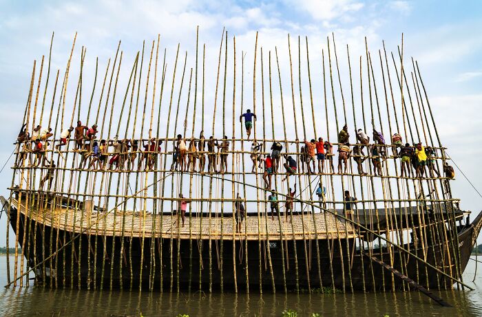 Children climbing on bamboo structure over water in a vibrant scene of stunning color photography winners from the 1839 Awards