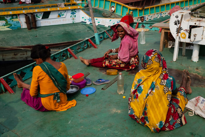 Three women sitting on a boat deck captured by a photographer traveling the world, showing candid street moments full of emotion.