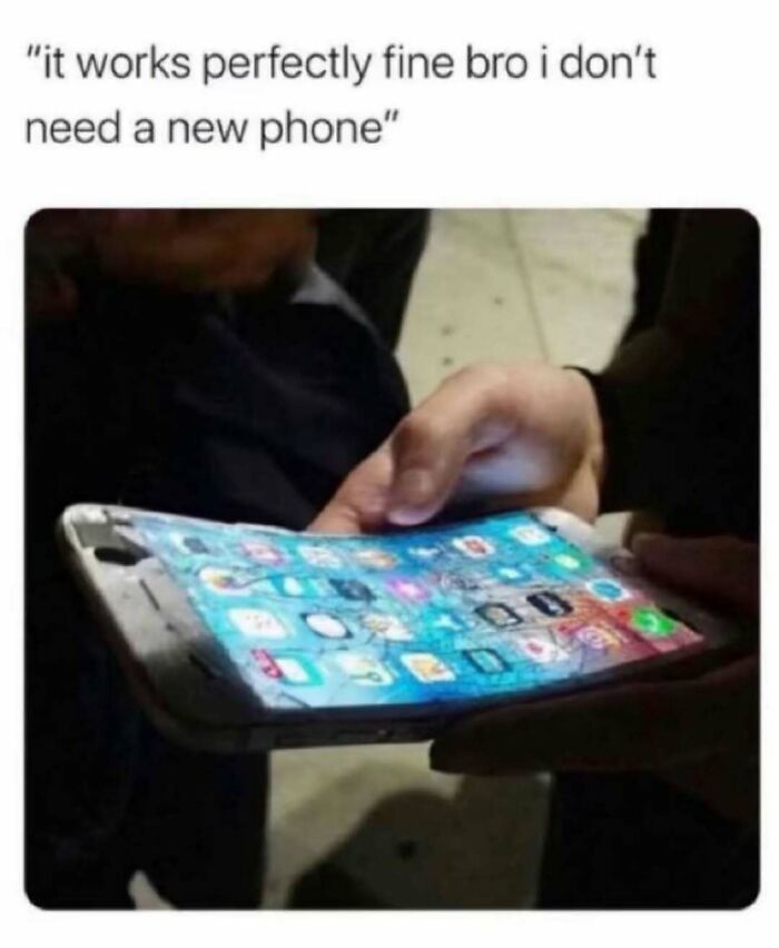 Person holding a severely c*****d phone screen with caption about not needing a new phone relatable energy meme.