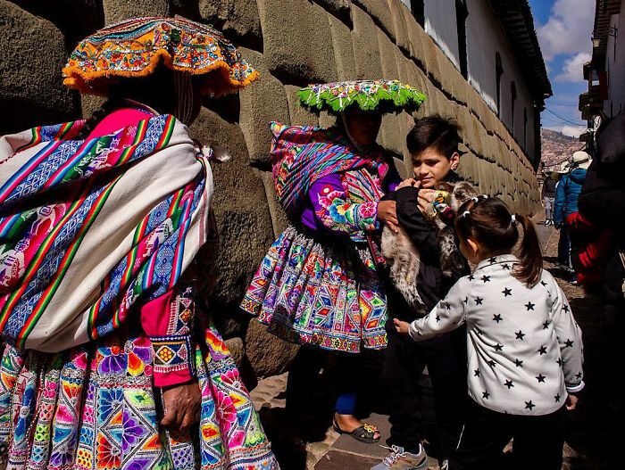 Colorful street scene showing locals and children interacting, capturing candid street moments full of emotion by photographer.