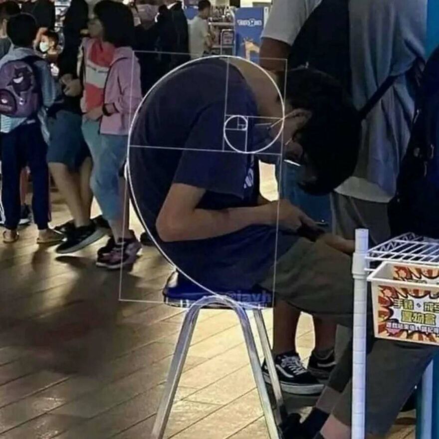 Person sitting on chair with Fibonacci spiral overlay, creating a visually bizarre yet hilarious moment in a crowded indoor space.