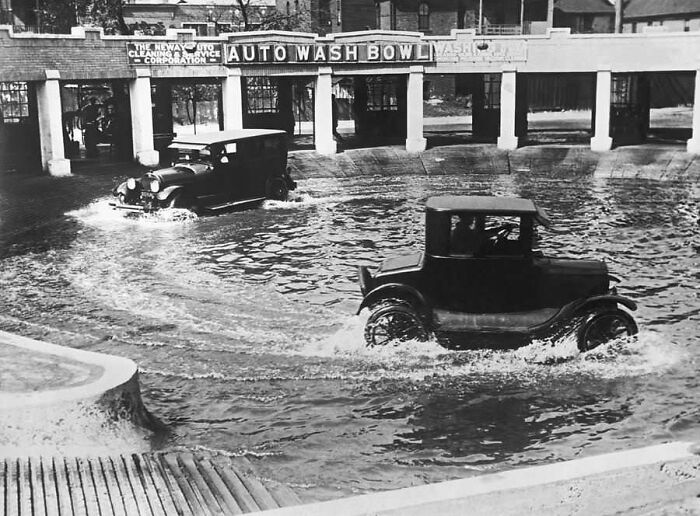 Vintage cars driving through a circular auto wash bowl, showcasing confusing historical technology and old vehicle design.