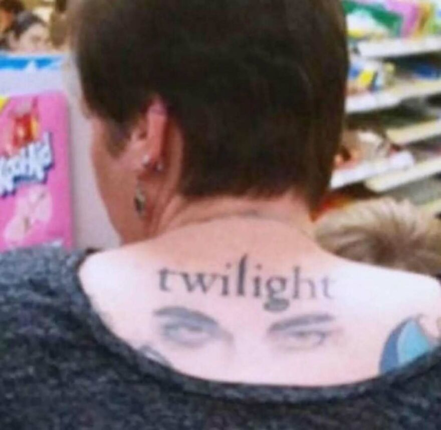 Tattoo of the word twilight with realistic eyes on a person's upper back in a casual indoor setting bizarre hilarious pic.