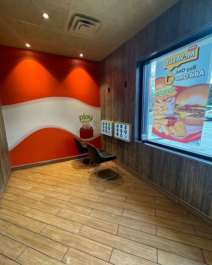 Small indoor play area with chairs and wall games inside a fast food restaurant, highlighting playful nature and animals theme.