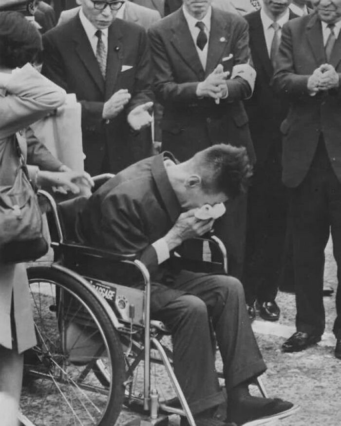 Man in wheelchair wiping tears while others in suits clap, illustrating surprise and emotion in weird history facts.