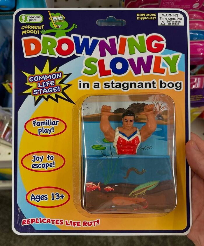 Funny fake toy packaging showing a man "drowning slowly in a stagnant bog" in a humorous product prank found in stores.