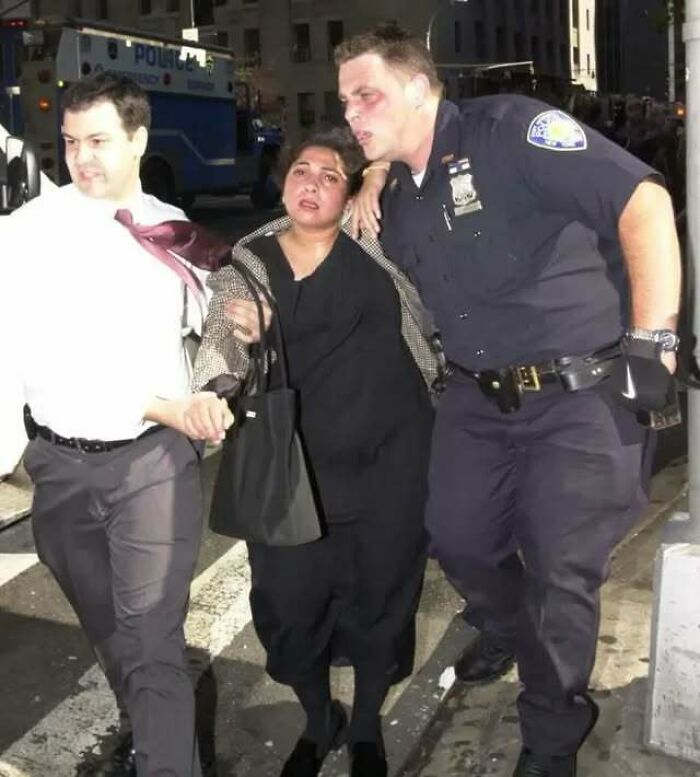 Woman being helped by police officers on a city street, illustrating a weird moment in history shared on Instagram.