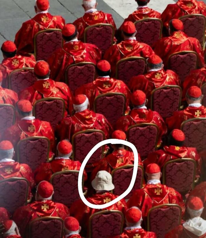 Group of people in red robes seated, with one person wearing a white bucket hat, showcasing unusual and random fun facts.