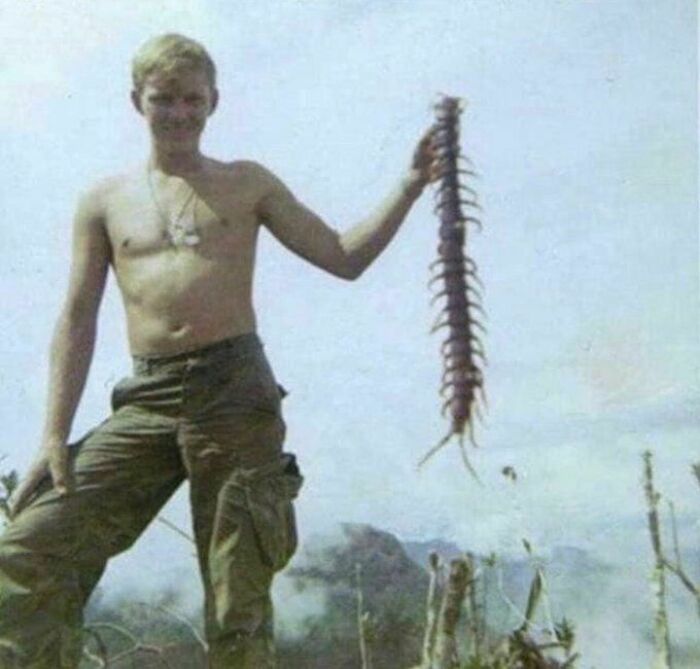 Young man outdoors holding a giant centipede, illustrating weird things about history from an Instagram account.