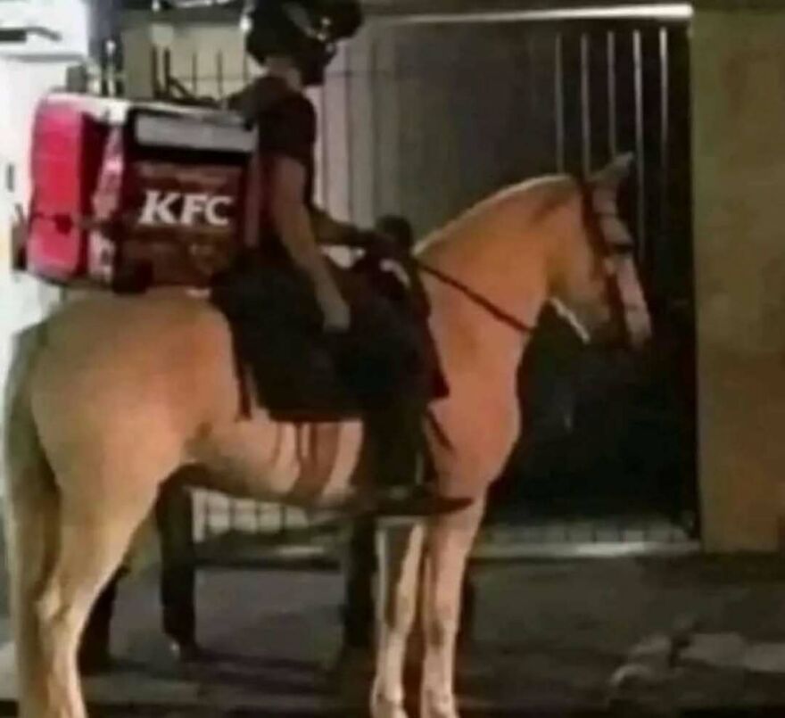 Delivery person with KFC backpack riding a horse at night in a bizarre yet hilarious scene.