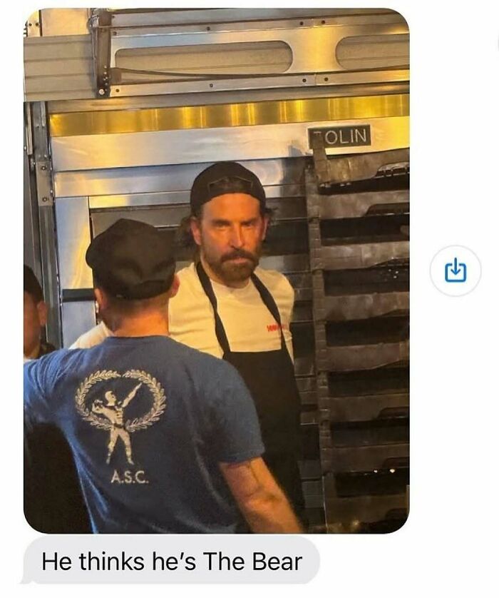 Man in black apron and cap standing by oven racks in a kitchen, a bizarre image from nature animals and random fun facts.