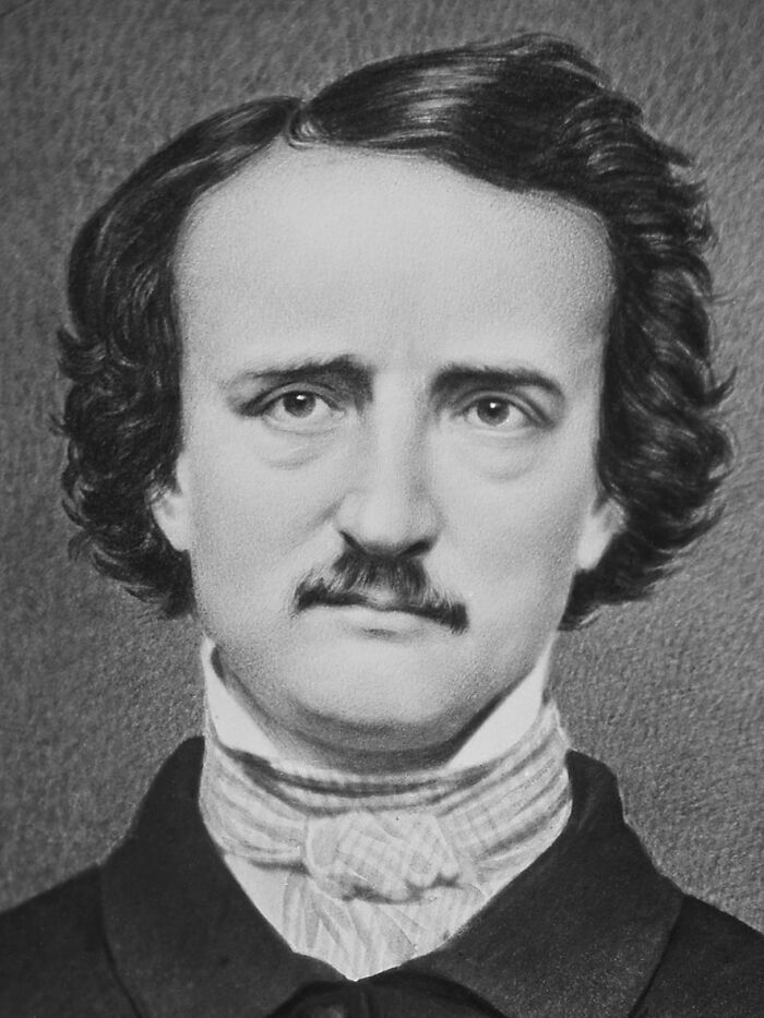 Black and white portrait of Nikola Tesla, showcasing his distinctive hairstyle and serious expression.