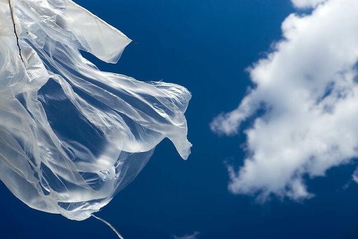 Transparent plastic bag floating in the air against a blue sky, showing a magical moment of city life coincidence.