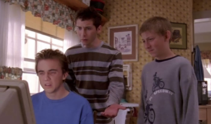 Three young male characters from Malcolm In The Middle looking at a computer screen in a vintage kitchen setting. Three young male characters from Malcolm In The Middle looking at a computer screen in a vintage kitchen setting.
