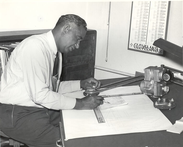 Man of color using drafting tools at a desk, representing world-changing inventions by people of color.