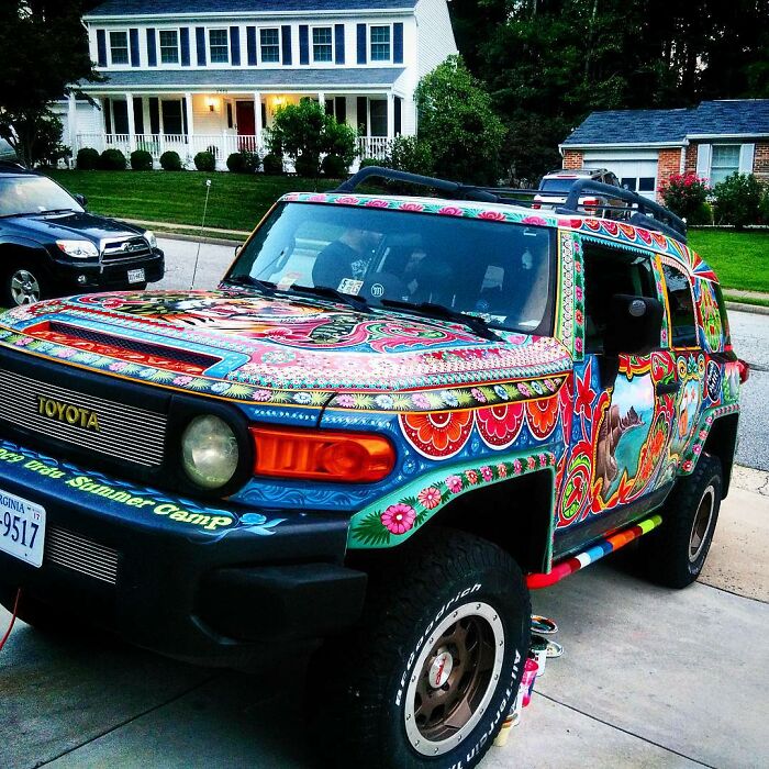 Colorful, intricate patterns painted on a Toyota SUV, transforming the car into a stunning work of art by an artist.
