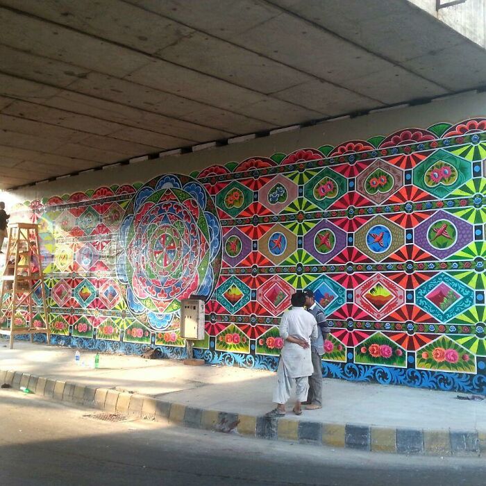 Vibrant colorful intricate patterns painted on a large wall transforming it into stunning street art.