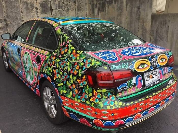 Car covered in colorful, intricate patterns turning it into a stunning work of art by a talented artist.