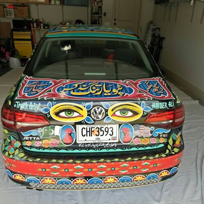 Car decorated with colorful, intricate patterns turning it into a stunning work of art by a creative artist.
