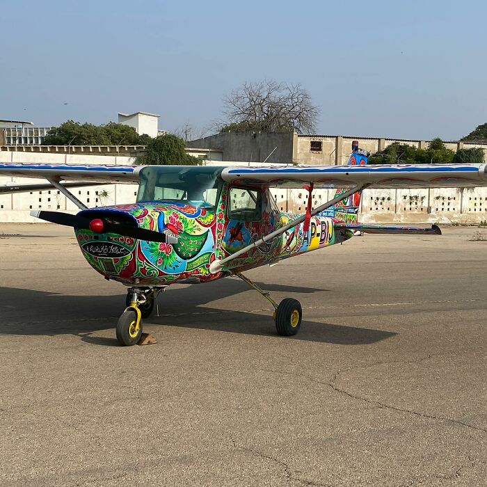 Small airplane painted with colorful, intricate patterns, showcasing the artist's stunning work on vehicles.
