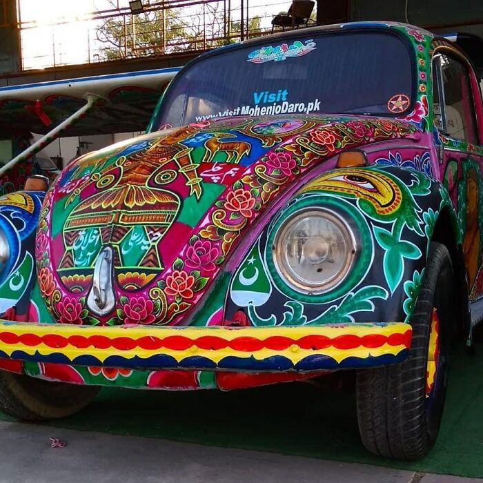 A vintage car covered in colorful, intricate patterns transforming it into a stunning work of art.