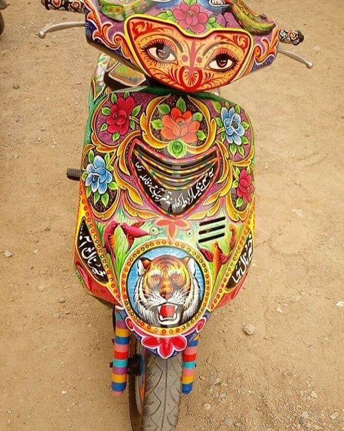 Colorful, intricate patterns transforming a scooter into a stunning work of art with floral and tiger designs.